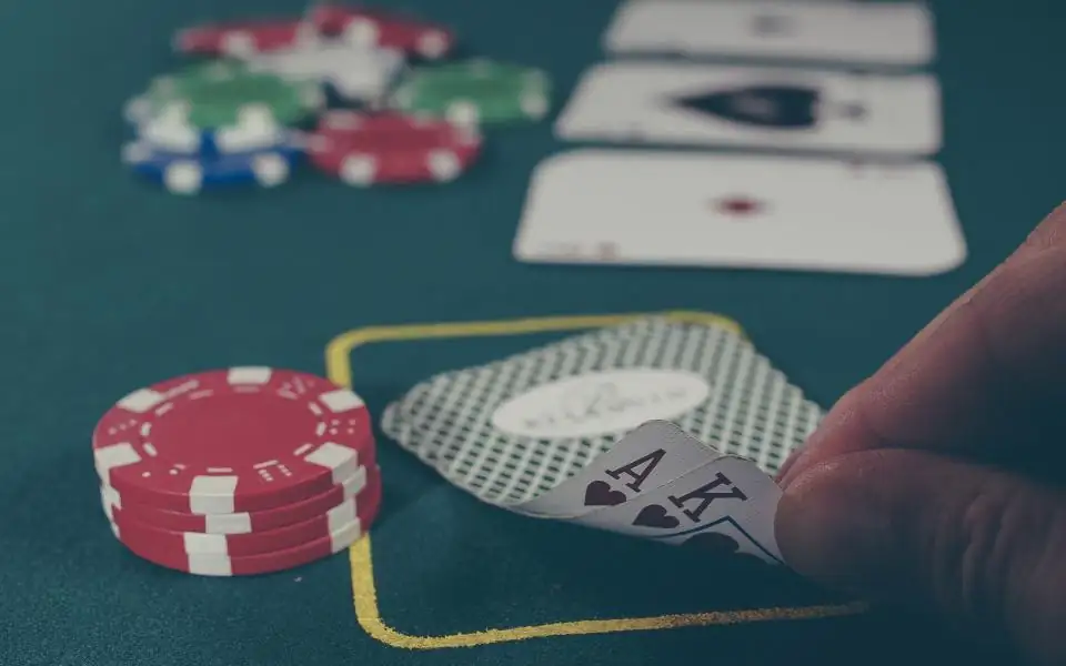 Casino chips and cards on a green live casino table at 218PLUSPH